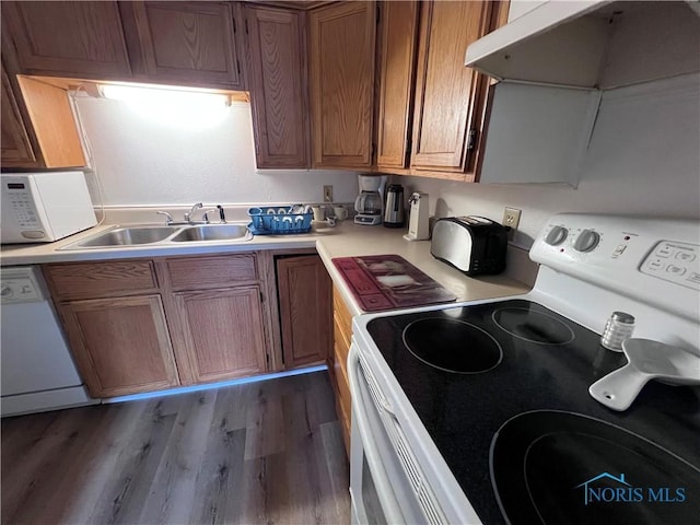 kitchen featuring sink, light hardwood / wood-style floors, and white appliances