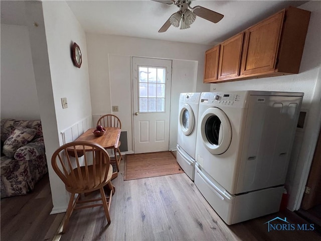 laundry area featuring ceiling fan, light hardwood / wood-style floors, cabinets, and washing machine and clothes dryer