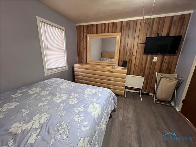 bedroom with wooden walls and wood-type flooring