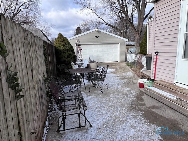 view of patio with a garage and an outbuilding