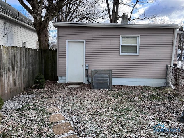 rear view of property featuring an outbuilding and cooling unit