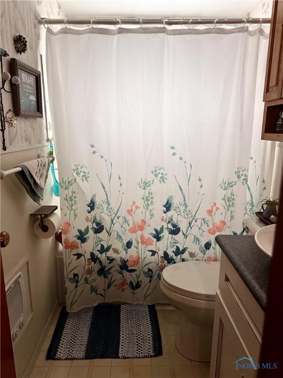 bathroom with a shower with curtain, tile patterned floors, vanity, and toilet