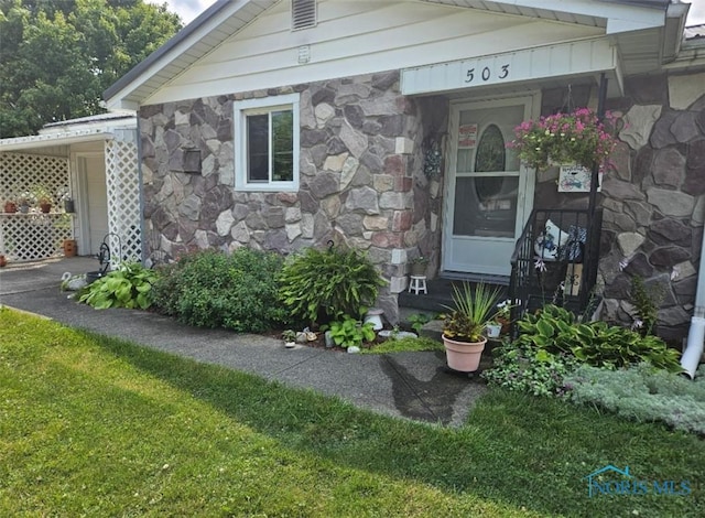 property entrance with a lawn