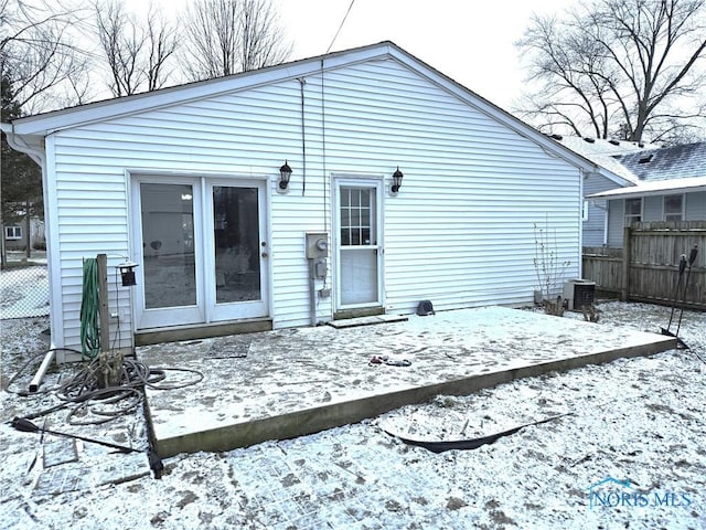 view of snow covered back of property