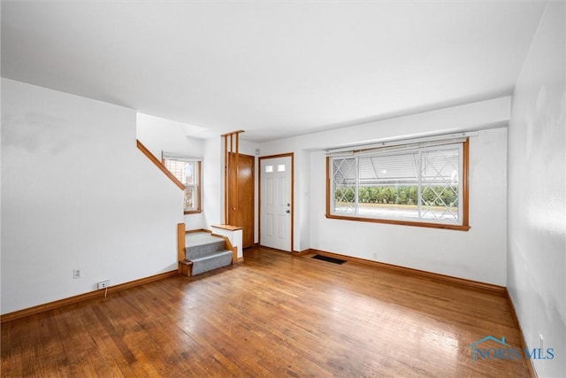 unfurnished living room with hardwood / wood-style floors and a healthy amount of sunlight