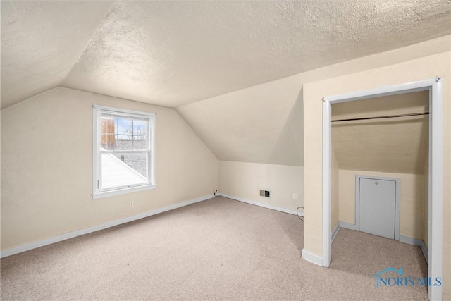 bonus room featuring light carpet, a textured ceiling, and vaulted ceiling