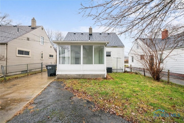 back of house featuring central AC, a lawn, and a sunroom