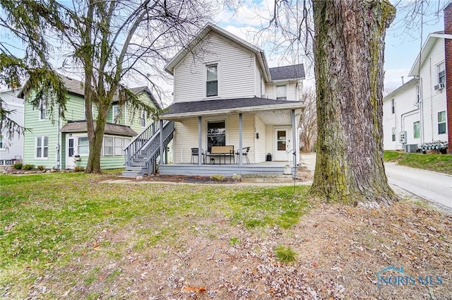 rear view of property with a lawn and covered porch