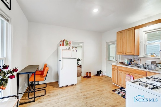 kitchen featuring light brown cabinets, white appliances, light hardwood / wood-style floors, and sink