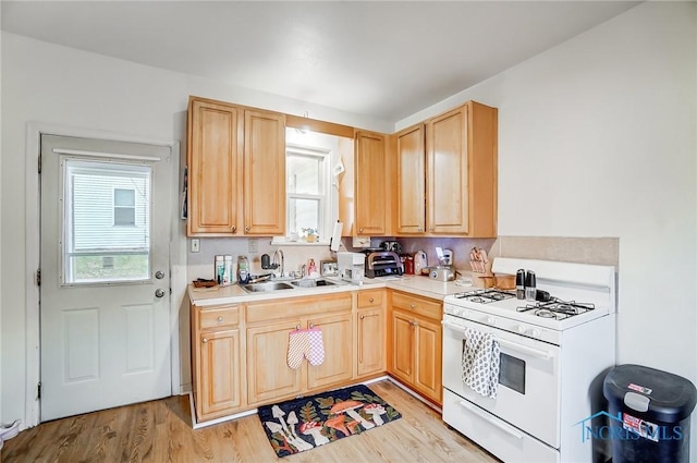 kitchen featuring sink, light wood-type flooring, light brown cabinets, and white gas range oven