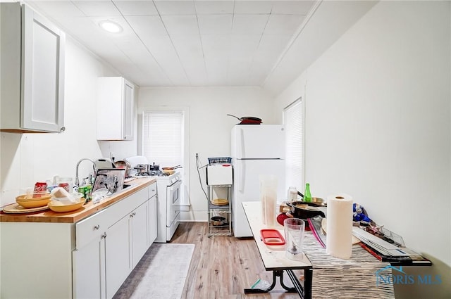 kitchen with white cabinetry, sink, white appliances, and light wood-type flooring