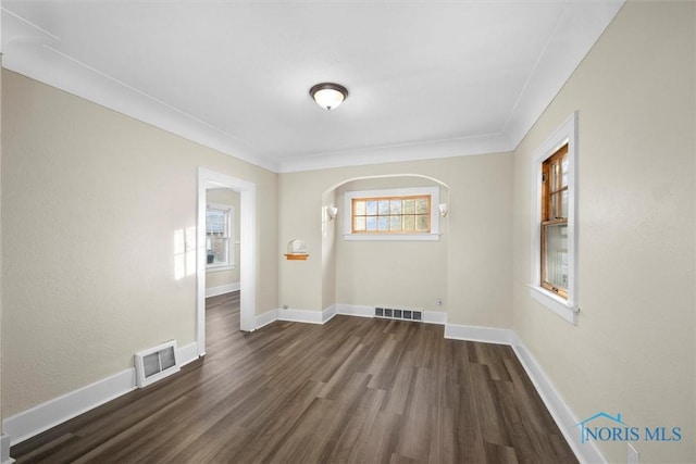 spare room featuring crown molding and dark hardwood / wood-style flooring