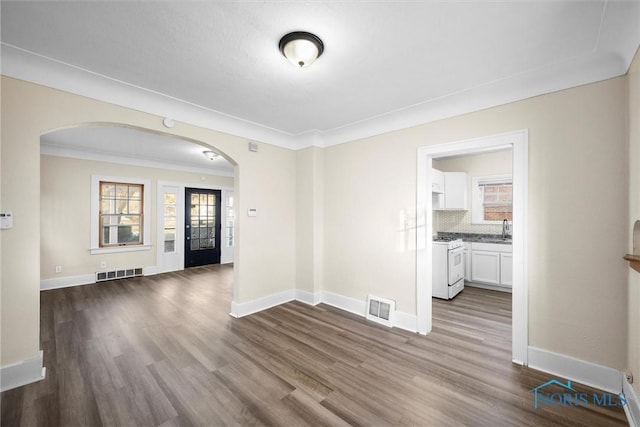 empty room with sink, ornamental molding, and hardwood / wood-style flooring