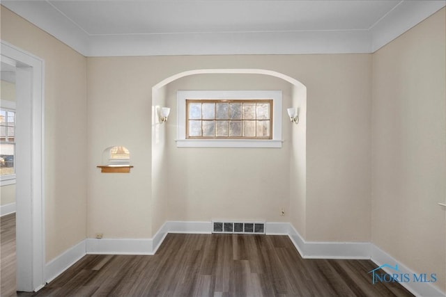 unfurnished room featuring plenty of natural light and dark wood-type flooring