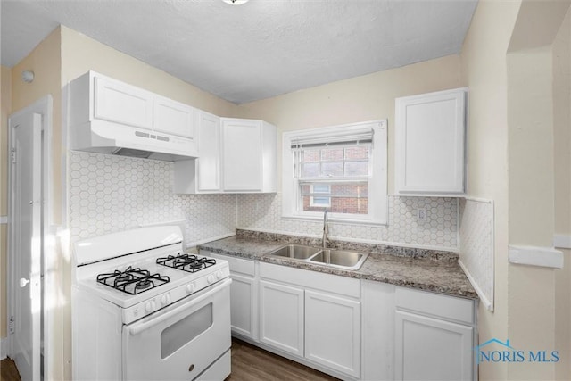 kitchen featuring sink, dark wood-type flooring, white range with gas stovetop, decorative backsplash, and white cabinets