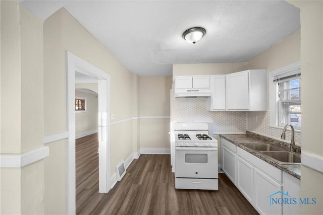 kitchen with decorative backsplash, sink, dark hardwood / wood-style floors, white cabinetry, and white gas stove