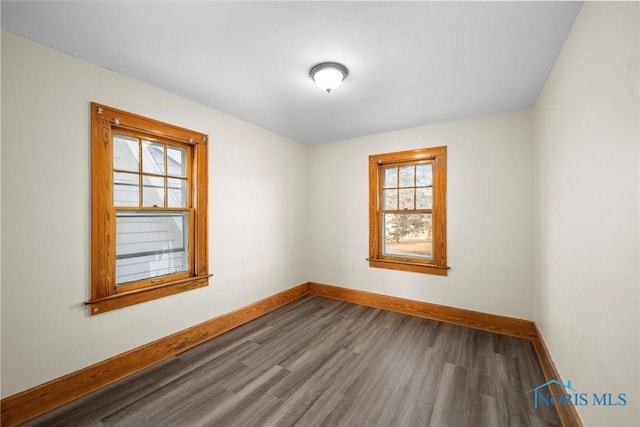 empty room with a healthy amount of sunlight and wood-type flooring