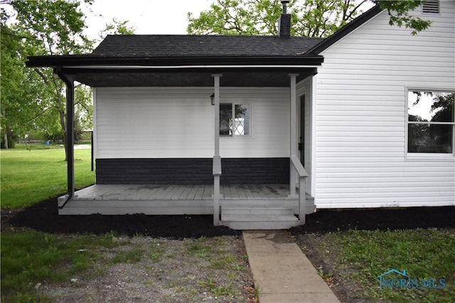 wooden terrace with covered porch and a lawn