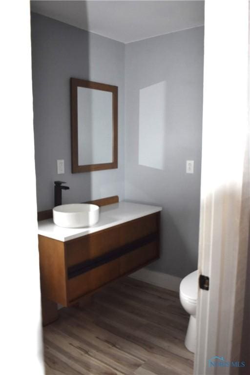 bathroom featuring hardwood / wood-style floors, vanity, and toilet