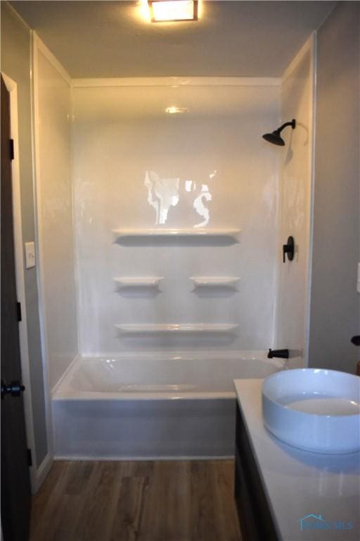 bathroom with hardwood / wood-style flooring and washtub / shower combination