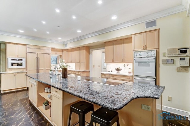 kitchen with black electric stovetop, paneled built in fridge, an island with sink, and double oven