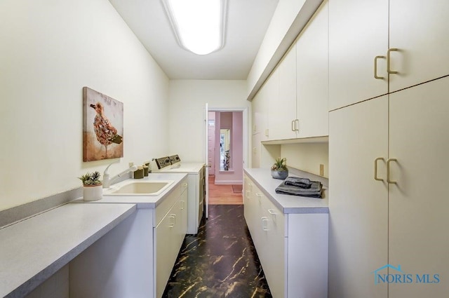 clothes washing area with cabinets, separate washer and dryer, and sink