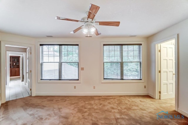 carpeted empty room with plenty of natural light and ceiling fan