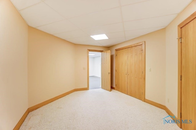 carpeted spare room featuring a drop ceiling