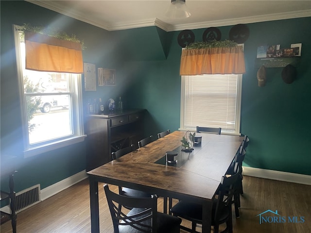 dining area with hardwood / wood-style floors and ornamental molding