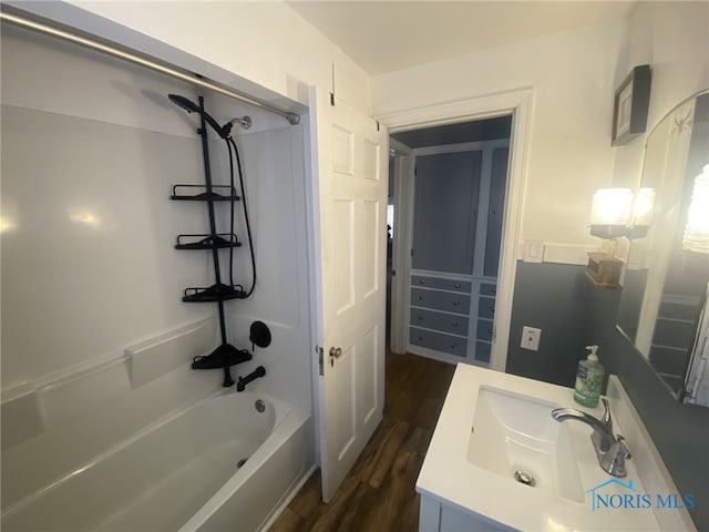 bathroom featuring wood-type flooring, vanity, and shower / bathing tub combination