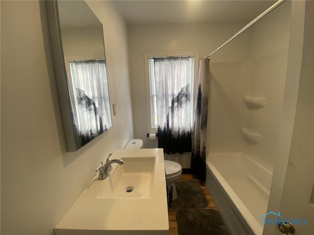 full bathroom with toilet, shower / tub combo with curtain, and sink