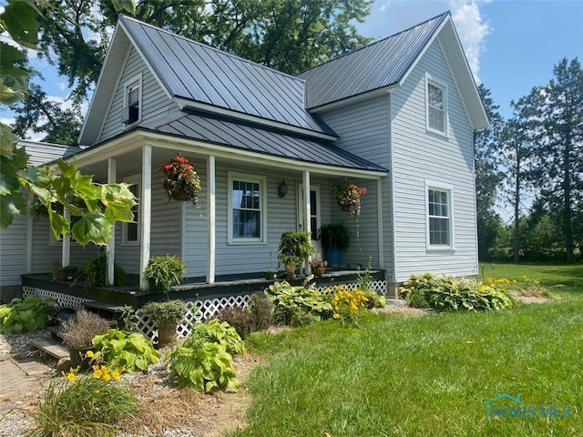 view of front of property featuring covered porch and a front yard