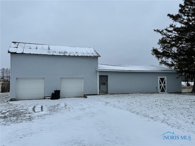 snow covered property with a garage