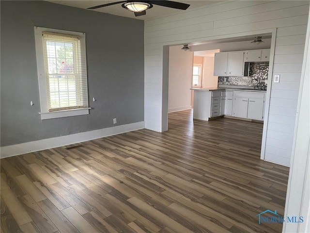 unfurnished living room with dark hardwood / wood-style flooring and sink