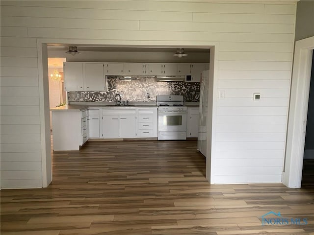 kitchen with decorative backsplash, white appliances, dark wood-type flooring, sink, and white cabinetry