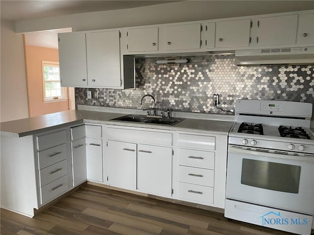 kitchen with white cabinets, sink, white gas range oven, tasteful backsplash, and kitchen peninsula