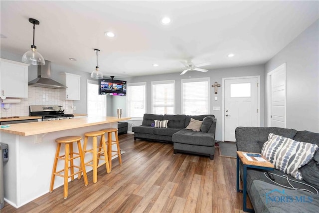 living area featuring a ceiling fan, light wood-style flooring, and recessed lighting