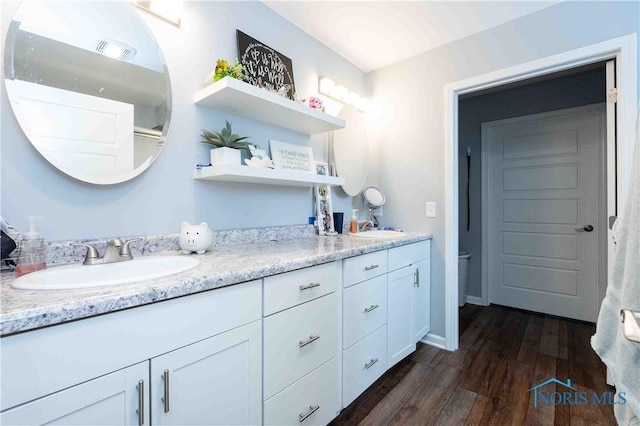 bathroom with double vanity, visible vents, wood finished floors, and a sink