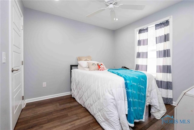 bedroom featuring baseboards, wood finished floors, and a ceiling fan