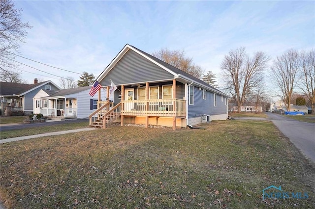 bungalow with covered porch and a front yard