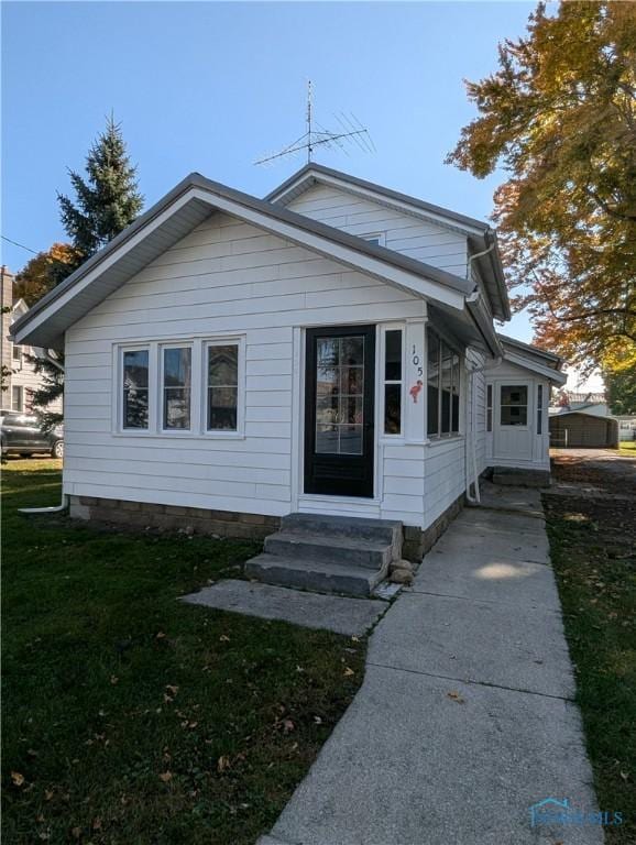 bungalow-style home featuring a front lawn