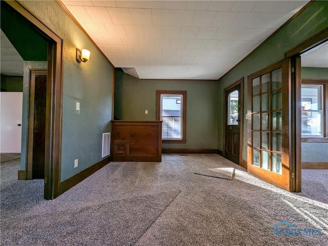 empty room featuring carpet and crown molding