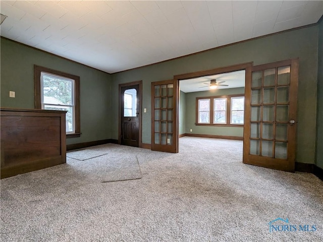 entryway featuring carpet flooring, french doors, ceiling fan, and crown molding