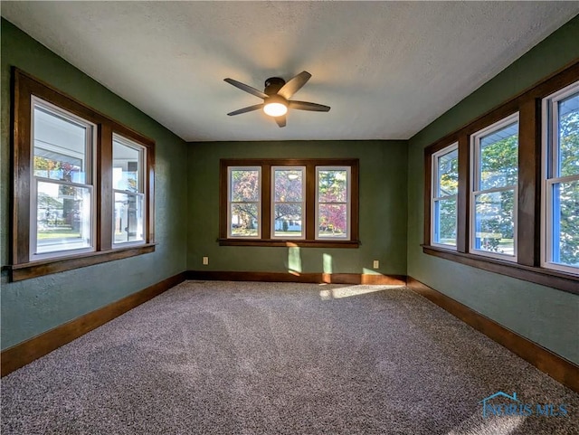 unfurnished room with carpet flooring, ceiling fan, and a textured ceiling