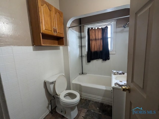 full bathroom featuring vanity, washtub / shower combination, tile walls, and toilet