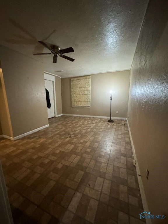 empty room featuring ceiling fan and a textured ceiling