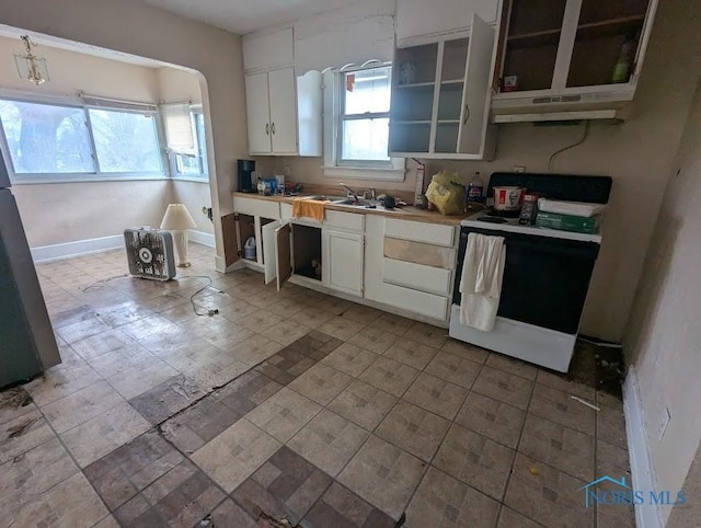 kitchen featuring refrigerator, electric range, sink, and white cabinets