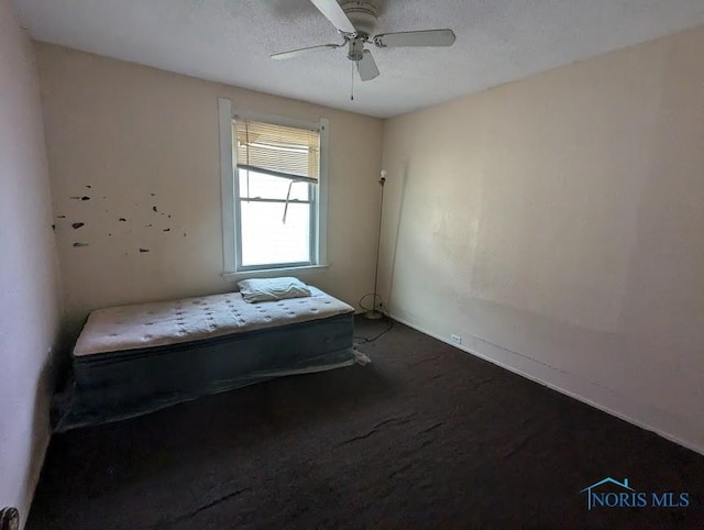 unfurnished bedroom with a textured ceiling, carpet floors, and ceiling fan