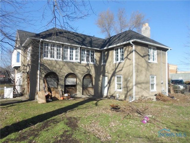 rear view of house featuring a lawn