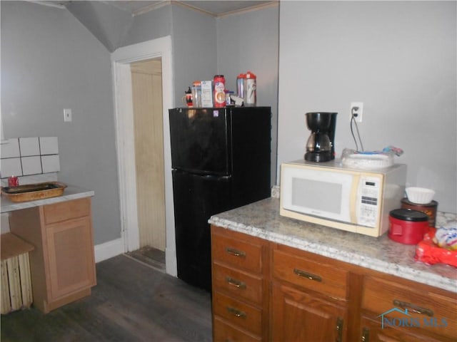 kitchen featuring black fridge and dark hardwood / wood-style floors